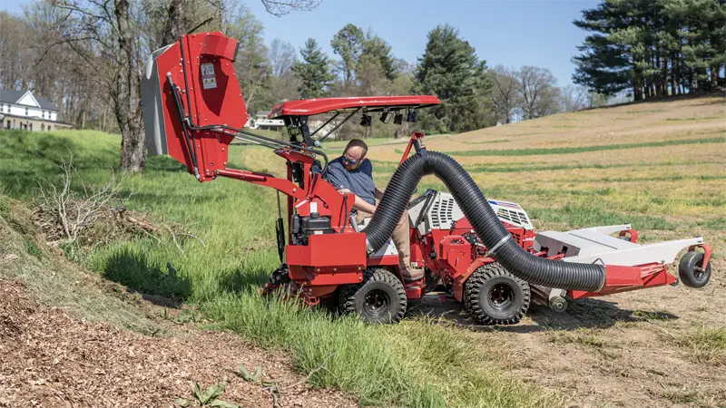The RV602 demonstrates its high-lift capability by unloading collected grass clippings into a dump trailer, streamlining the disposal process for large estates and municipalities.