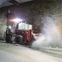 NJ380 Broom In front of a business entrance, the NJ380 Power Broom sweeps away snow and slush cleanly, providing safe, slip-resistant access for customers even after heavy snowfall.