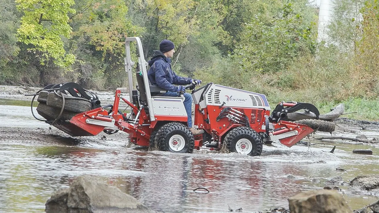 Tractor Dual Grapple Buckets to Help Clean A River